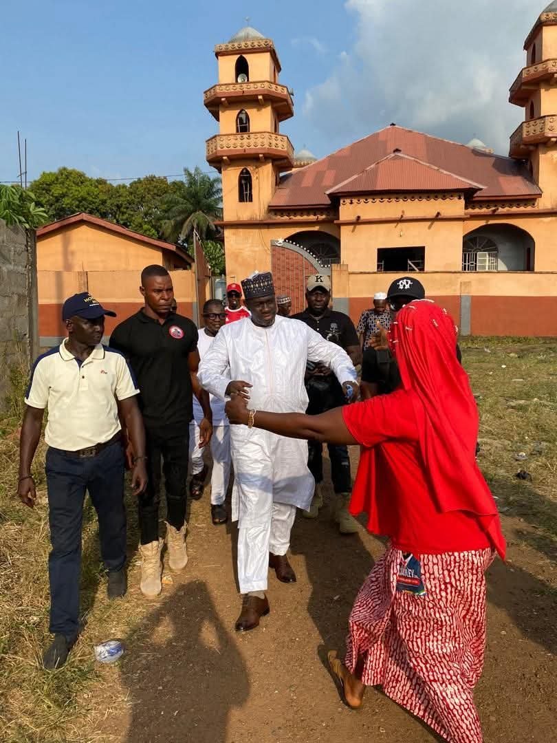 Sorie Sulaiman Sesay walking through a community with residents